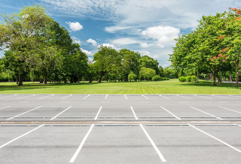 Empty parking lot with trees and grass., representing a Keystone Commercial Real Estate investment sale.
