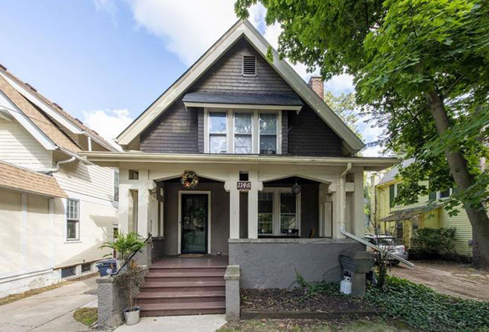 A two-story home with a porch and front yard, located in Ann Arbor, Michigan, ideal for student housing.