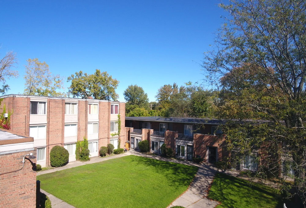 Aerial view of courtyard at Detroit apartment complex, surrounded by lush greenery and well-maintained pathways.